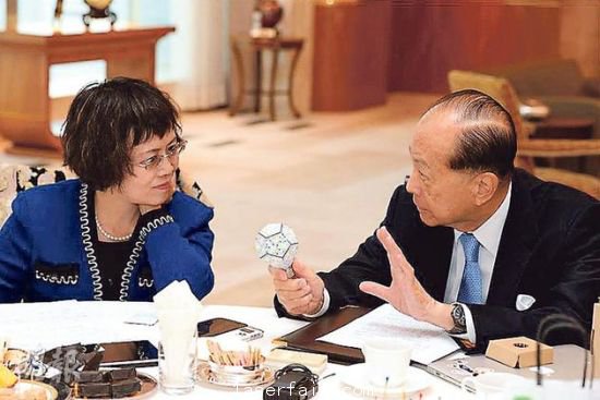 李嘉誠（右）在接受媒體訪問時指出，長實集團以香港為基地，常常積極在港尋找投資機會，但是政府很多政策，需時消化。圖為他向財新傳媒總編輯胡舒立介紹他本周的&ldquo;最愛&rdquo;納米LED燈泡。圖片來源：香港明報